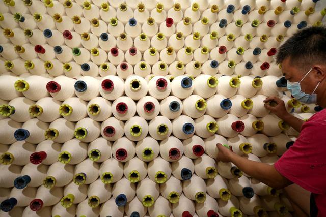 在山东省枣庄市税郭镇的一家纺织企业,工人在整理生产的粗纱产品